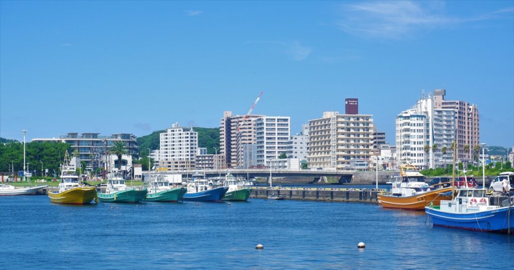 藤沢の港に停泊するカラフルな漁船と高層ビル群