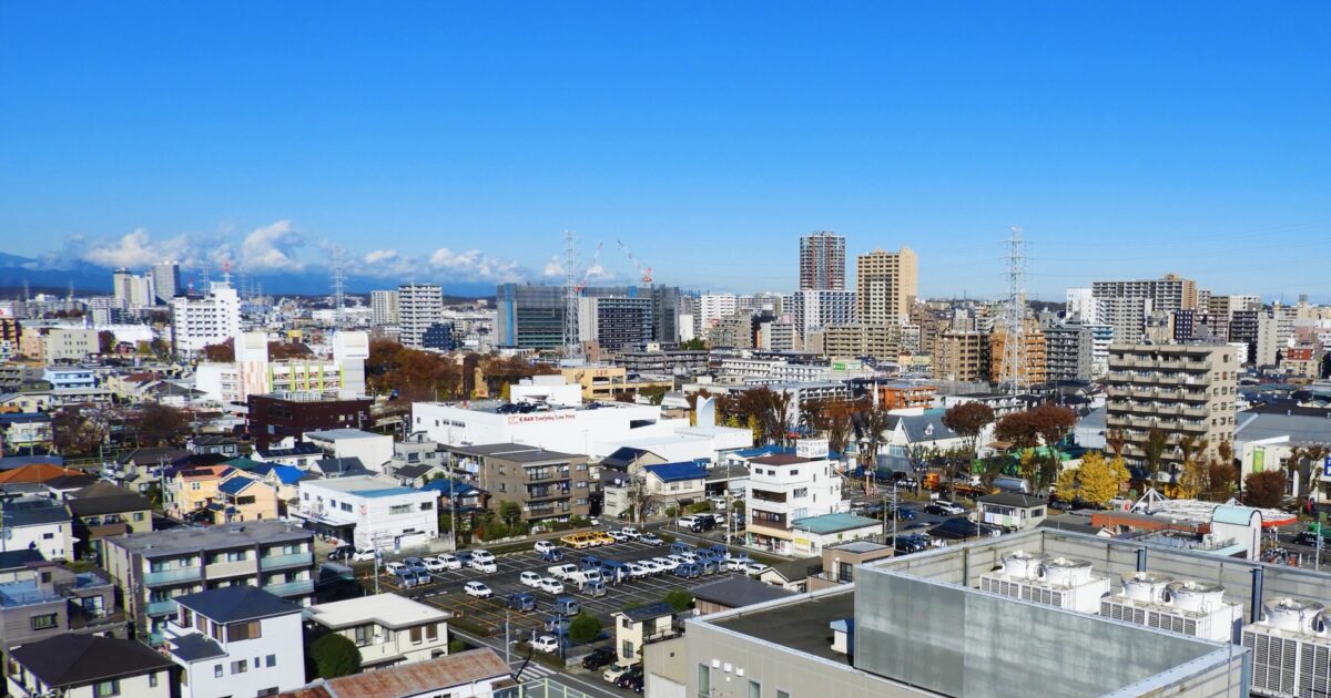 青空に広がる相模原市街地の高層マンション群と住宅地