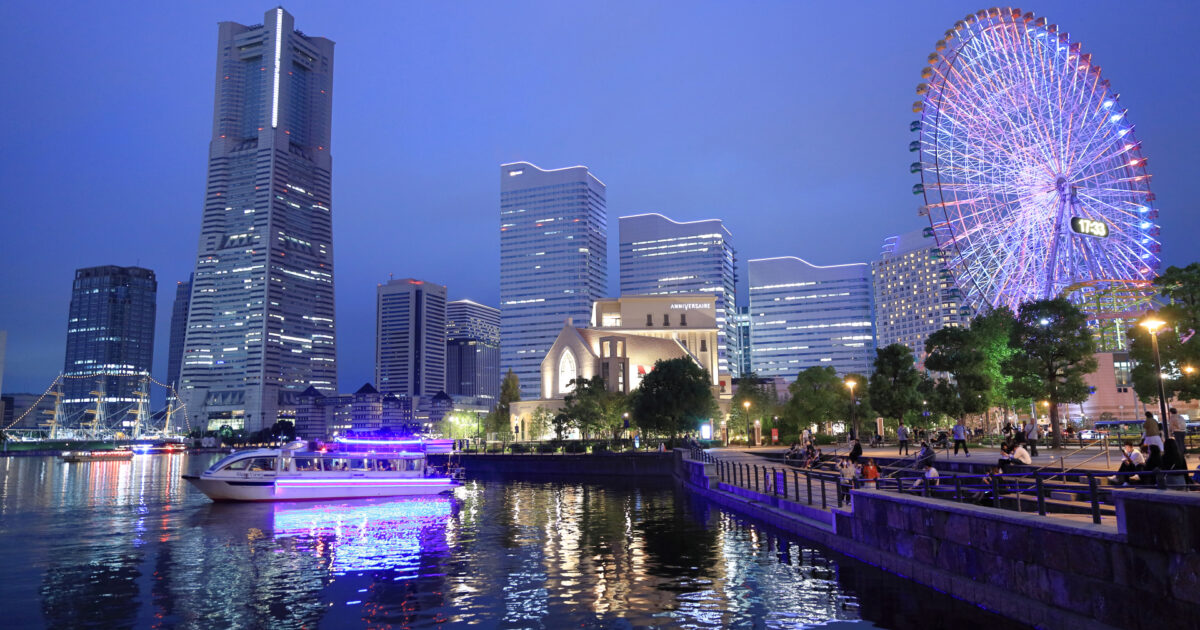 夕暮れ時の横浜みなとみらいと観覧車と遊覧船